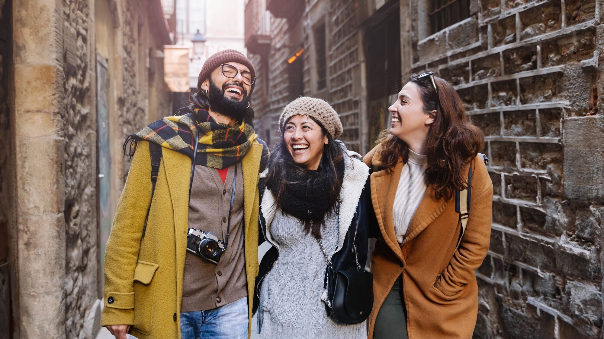 Tourist friends walking in historical old city, happy visiting town and enjoying winter vacations